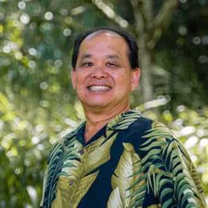 Dr. David Dung smiling outdoors in a tropical shirt on the Meet the Doctors page at Dung Orthodontics in Honolulu and Aiea, HI