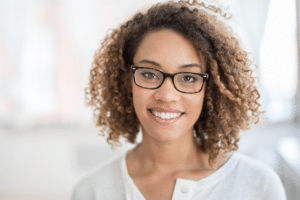 Smiling woman wearing glasses displaying a bright, healthy smile.