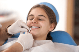 Young patient with metal braces smiling during a routine orthodontic adjustment